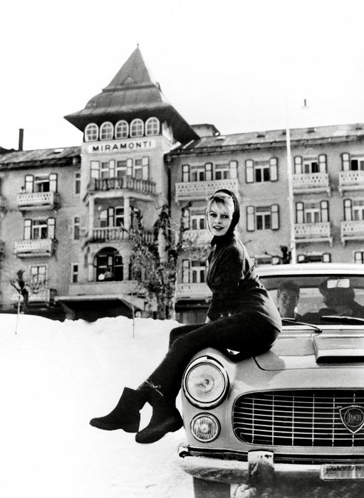 Brigitte Bardot sitting on a car